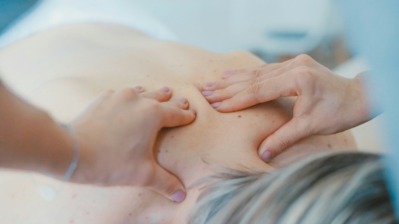 Handen die op een rug bindweefselmassage geven